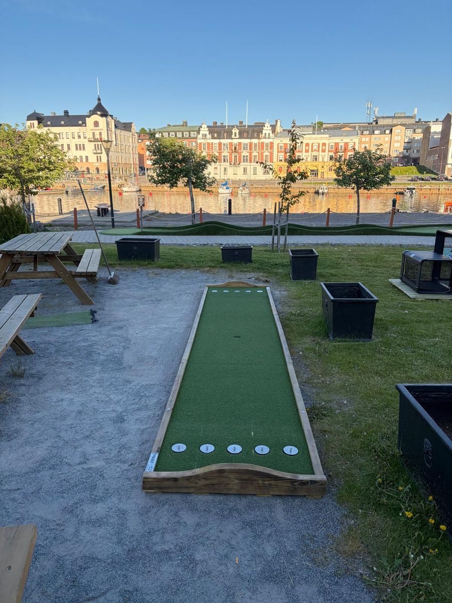 Kubbgolfbana utomhus med sittplatser och hamnutsikt